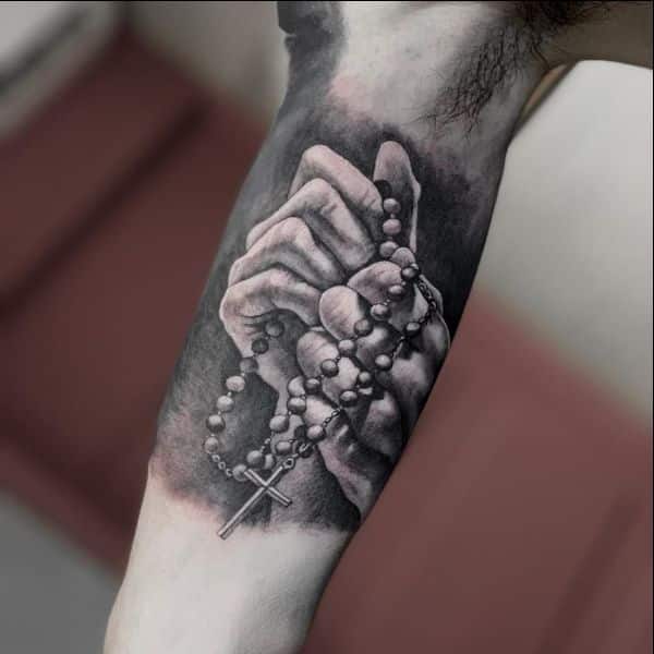 two hands holding cross tattoos